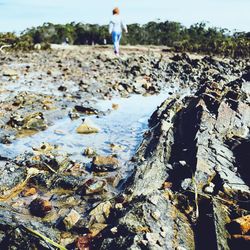 Full length of man standing on rocks at beach