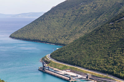 High angle view of sea by mountain against sky