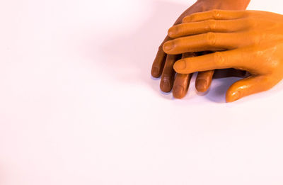 Close-up of hand on table against white background