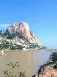 Scenic view of sea and mountains against clear blue sky