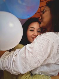 Portrait of mother and baby girl with balloons