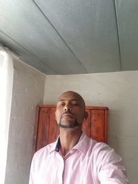 Portrait of man standing against wall