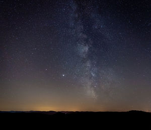 Scenic view of silhouette mountain against star field