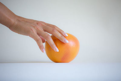 Midsection of woman against orange background