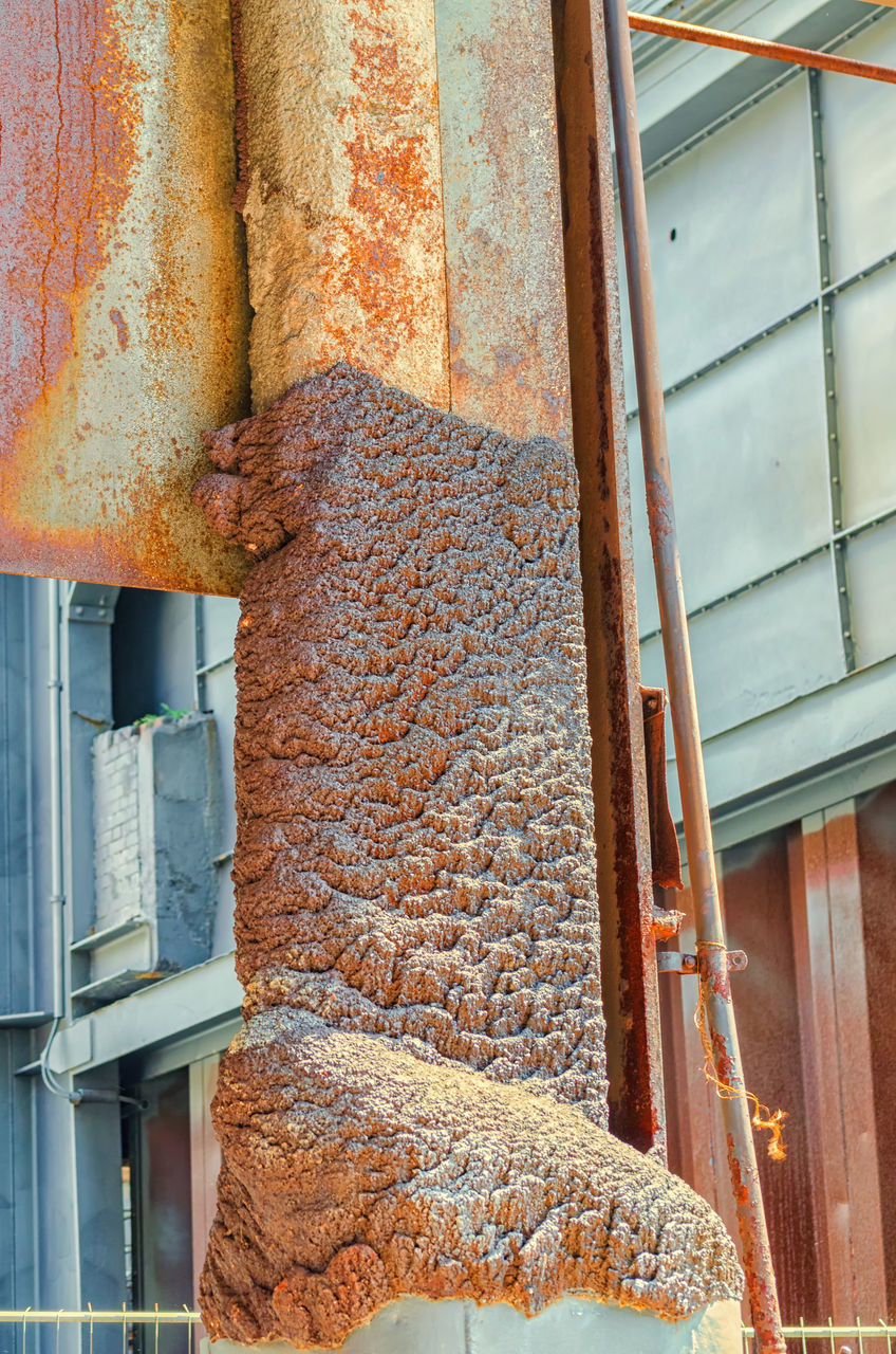 LOW ANGLE VIEW OF RUSTY HANGING ON BUILDING