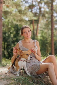 Portrait of young woman sitting on field