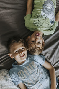 Portrait of brothers lying on bed