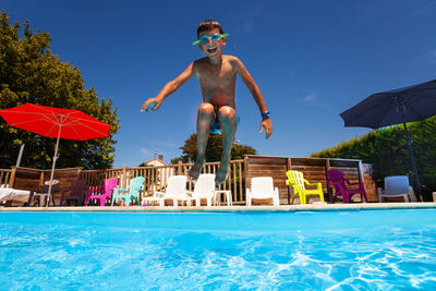 Full length of boy jumping in swimming pool