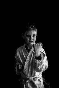 Portrait of young man against black background