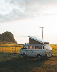 Cars on field against sky