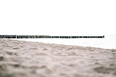 Surface level of beach against clear sky