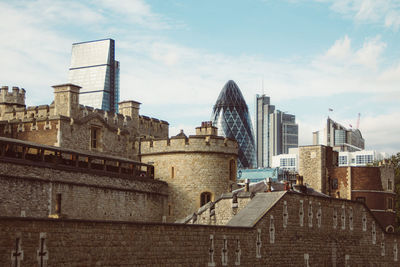 Low angle view of buildings against cloudy sky