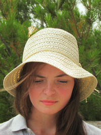 Close-up of beautiful young woman wearing hat