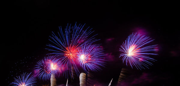 Low angle view of firework display at night