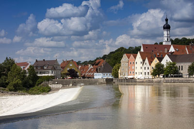 River amidst buildings in town against sky