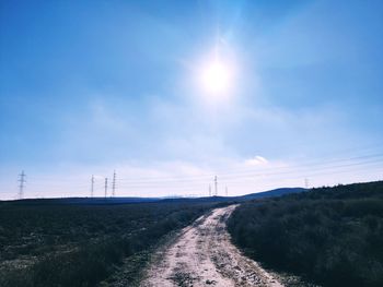 Road amidst field against sky