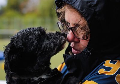 Close-up of mature woman playing with dog