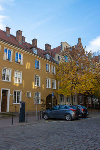 Cars on street by buildings against sky