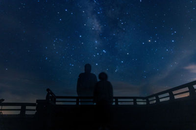 Low angle view of silhouette man standing against sky at night