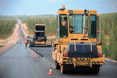 Bulldozer on road against sky