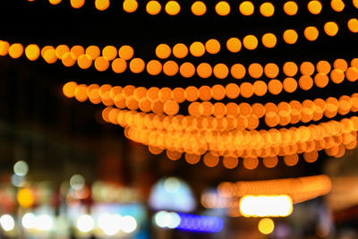 Close-up of illuminated lights hanging at night