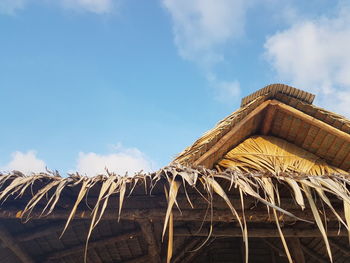 Low angle view of thatched roof against sky