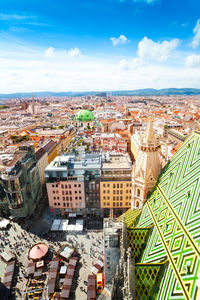 High angle view of city buildings against cloudy sky