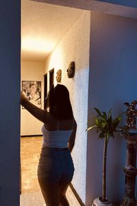 Rear view of woman standing against wall