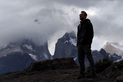 Full length of man standing on mountain against sky