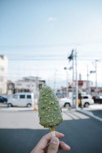 Close-up of hand holding ice cream cone on street