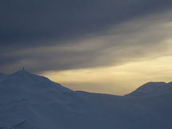 Scenic view of snowcapped mountains against sky during sunset