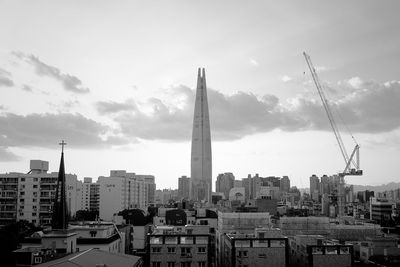 Buildings in city against cloudy sky