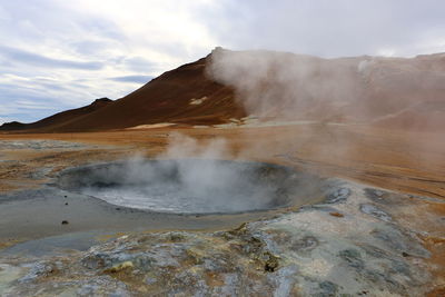 Smoke emitting from volcanic mountain against sky