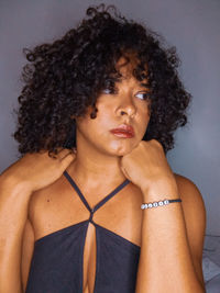 Close-up portrait of a young woman against gray background