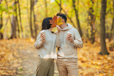 Young woman with arms outstretched in forest during autumn