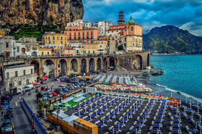 Panoramic view of people in town against cloudy sky