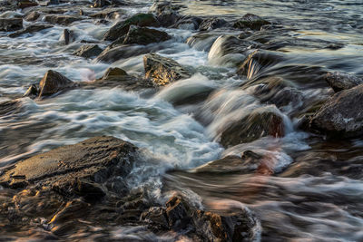 Stream flowing through rocks in sea