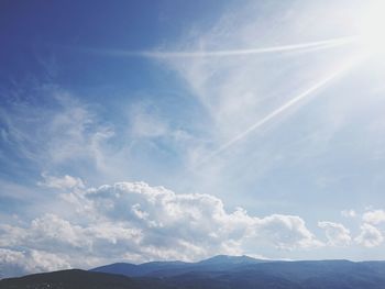 Scenic view of mountains against cloudy sky