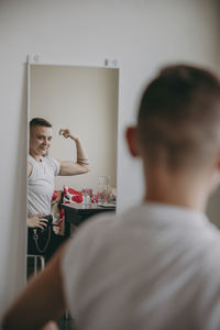 Woman flexing muscles in front of mirror