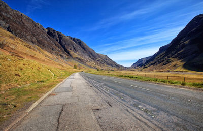 Road amidst landscape against blue sky