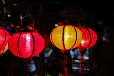 Close-up of illuminated lanterns hanging at night