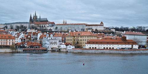 Buildings in city against cloudy sky