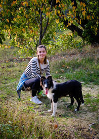 Side view of woman with dog on field