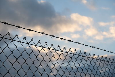Close-up of chainlink fence against sky