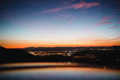 River by silhouette mountains against sky during sunset