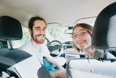 Portrait of happy couple sitting in car