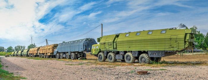 Train on railroad track amidst field against sky