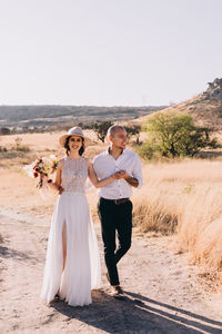 Rear view of couple walking against sky