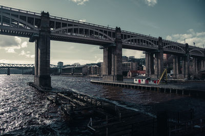 Bridge over river against cloudy sky