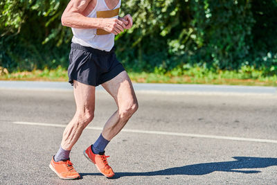 Low section of man running on road